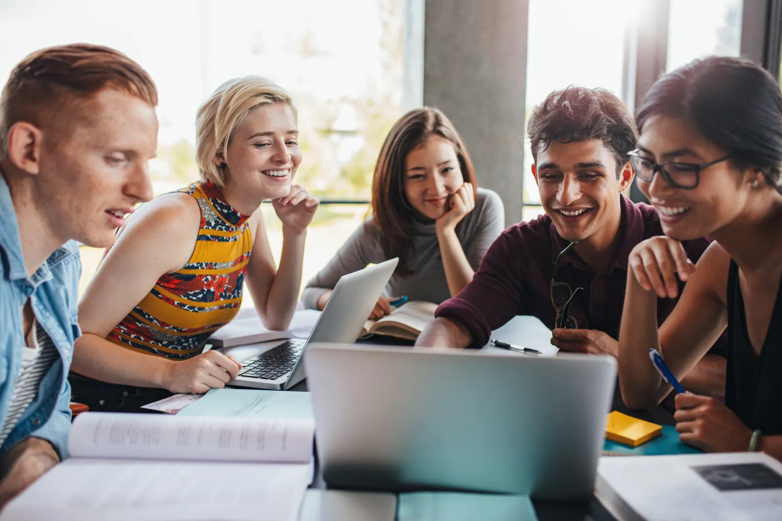 A group of people looking at a laptop together