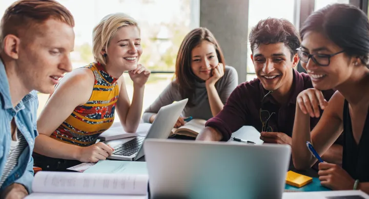 A group of people looking at a laptop together